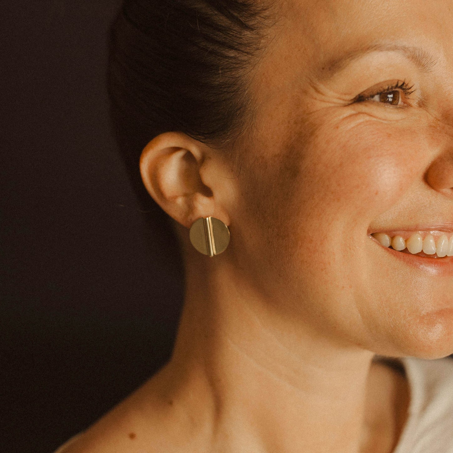 Gold Circle Coin Aegis Earring on Woman's Ear