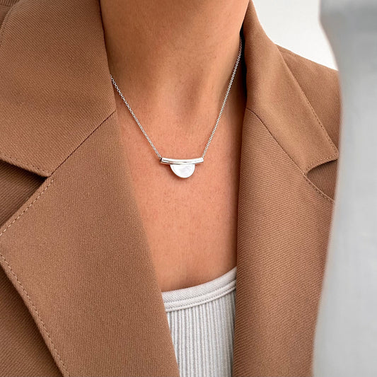 Modern Geometric Horizon line circle necklace in silver shown on woman's neck