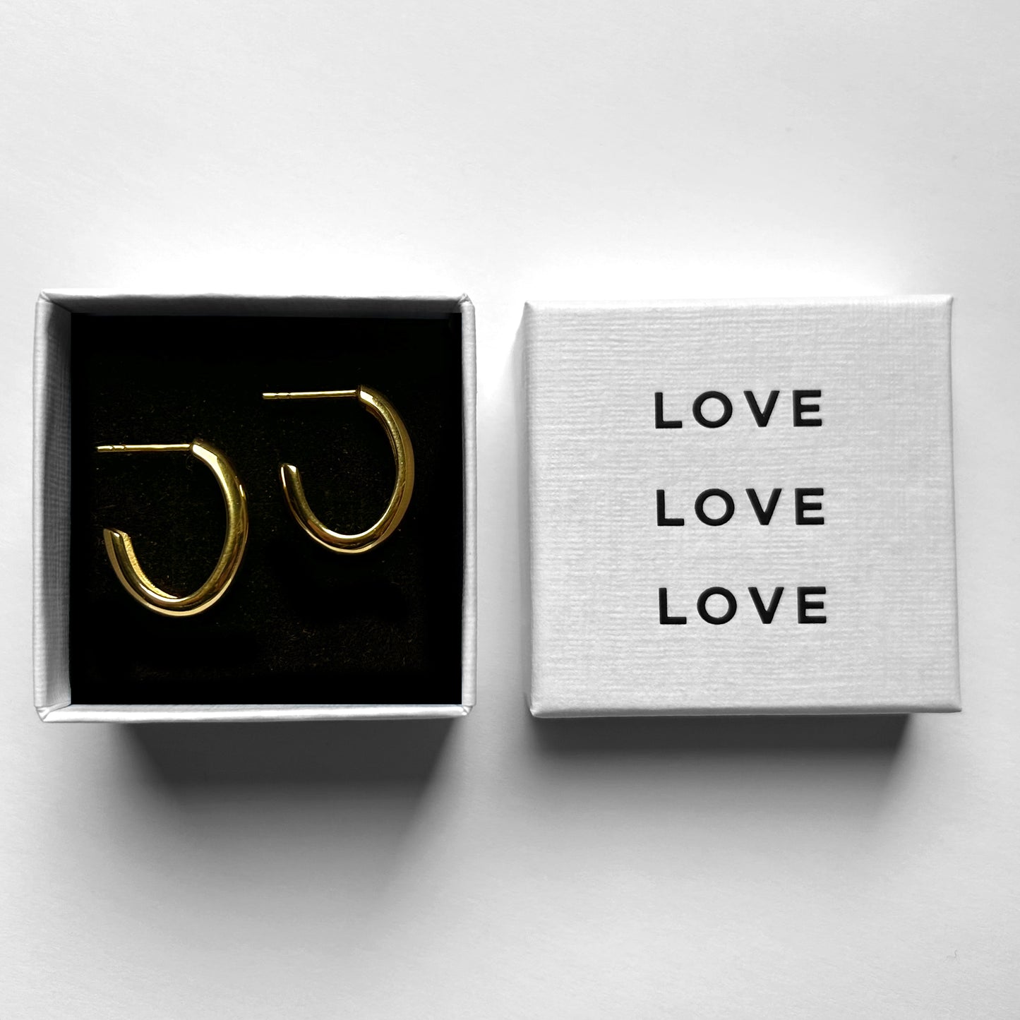 Modern Gold Hoop Aura Earrings shown in love jewelry box