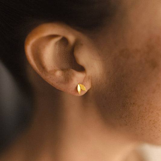 modern leaf stud earrings on woman's ear