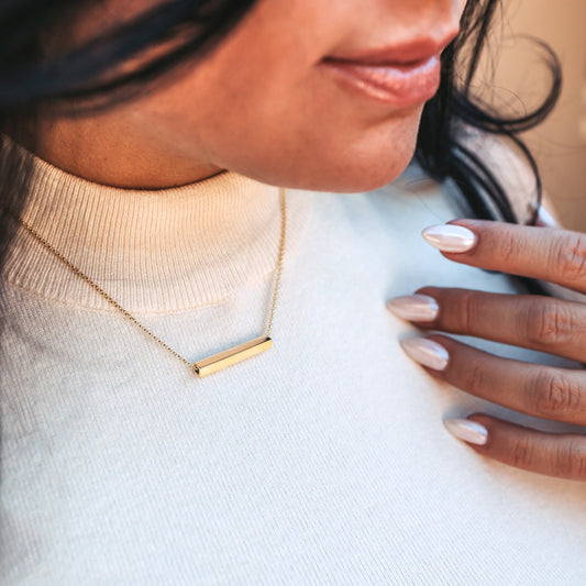 Modern Linear Line Gold Bar necklace on woman in white shirt with nice nails