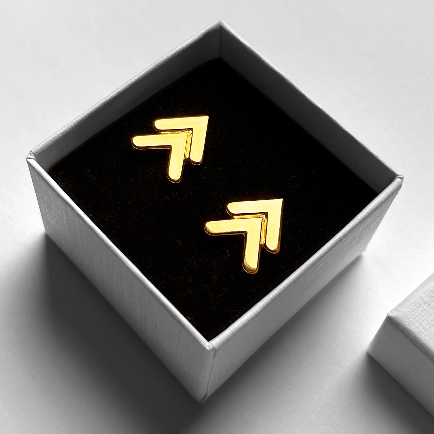 Modern Minimal Chevron Gold Earrings shown in white jewelry box with black velvet