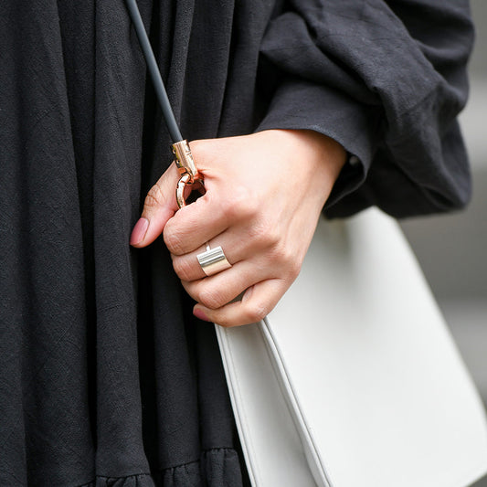Modern Silver Square Shield Ring on woman's finger with purse