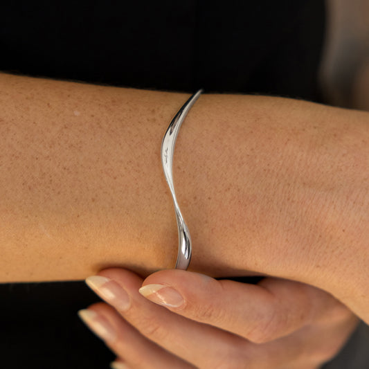 Silver bracelet on a wrist with a blurred background