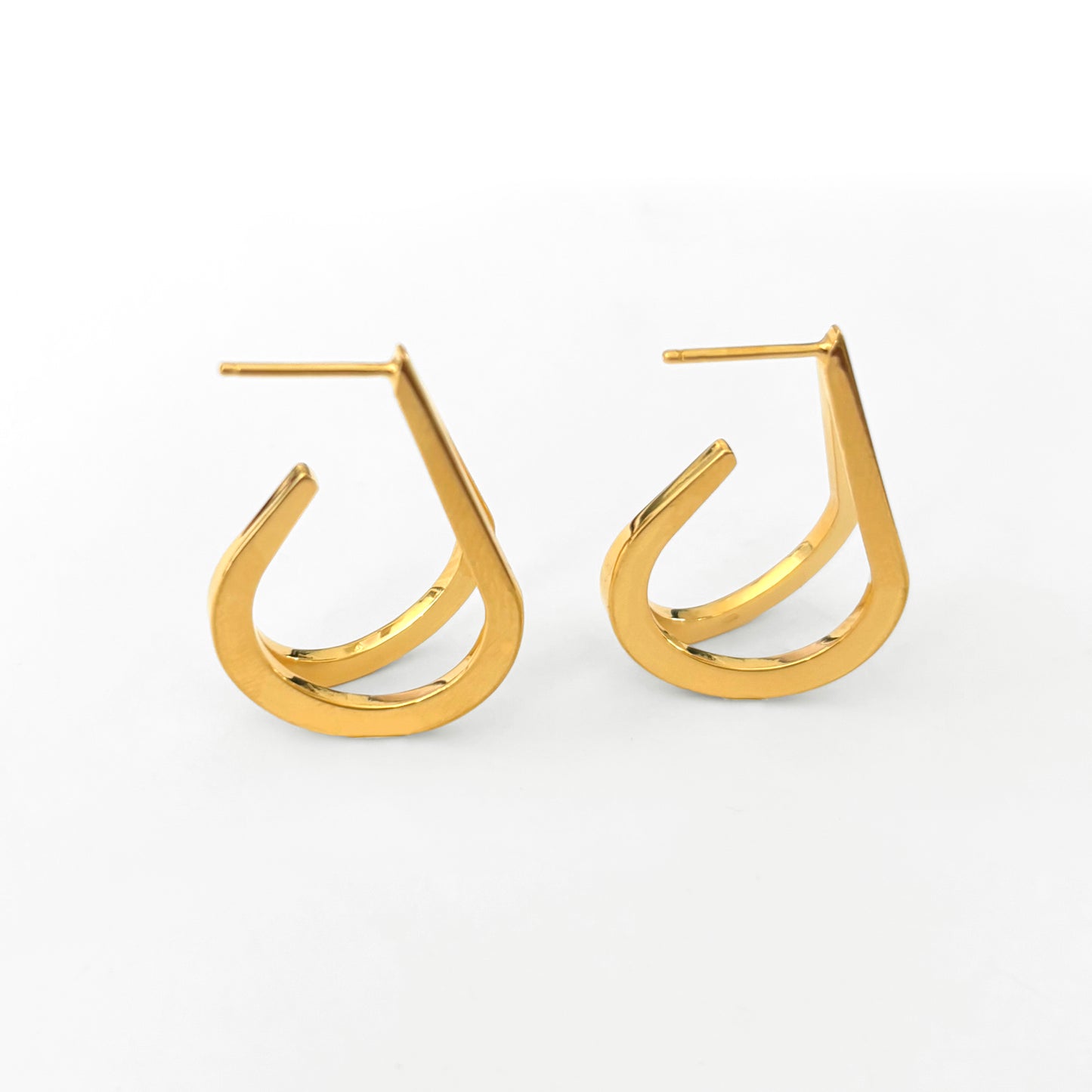 Gold hoop earrings on a light gray background