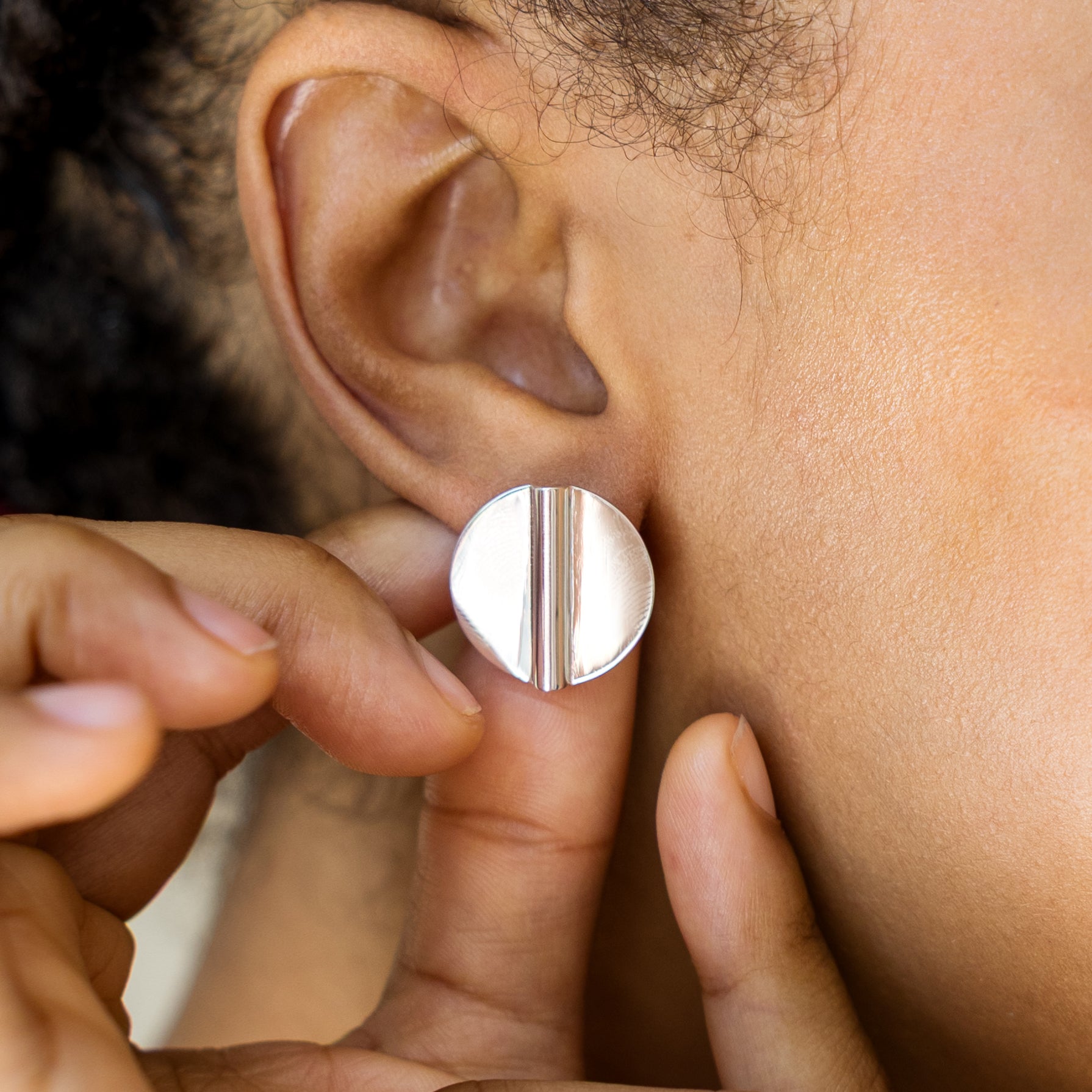 Close-up of a person wearing a silver earring.