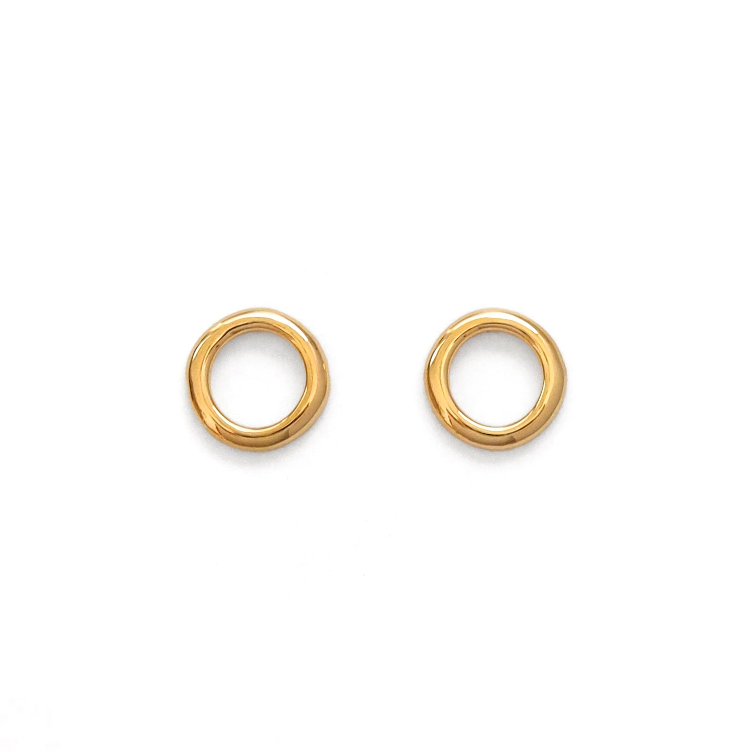 Pair of gold hoop circle earrings on a white background