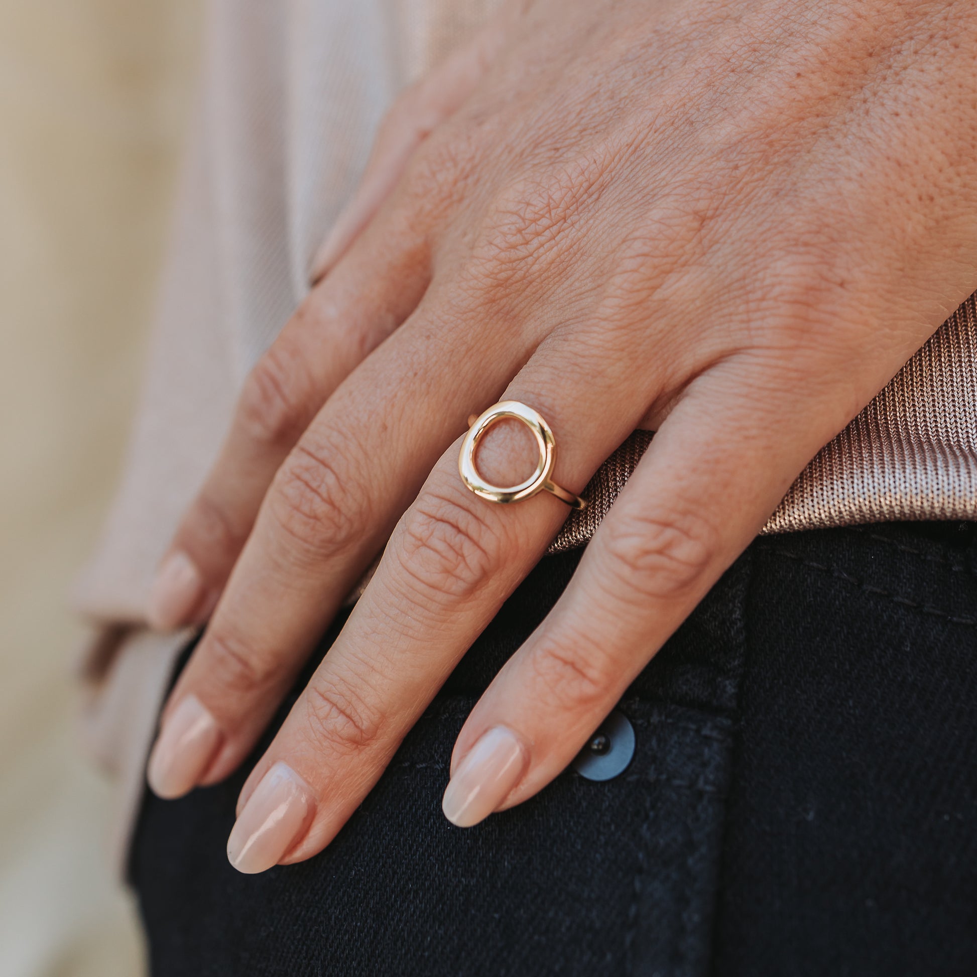 Close up of a hand wearing a circular ring