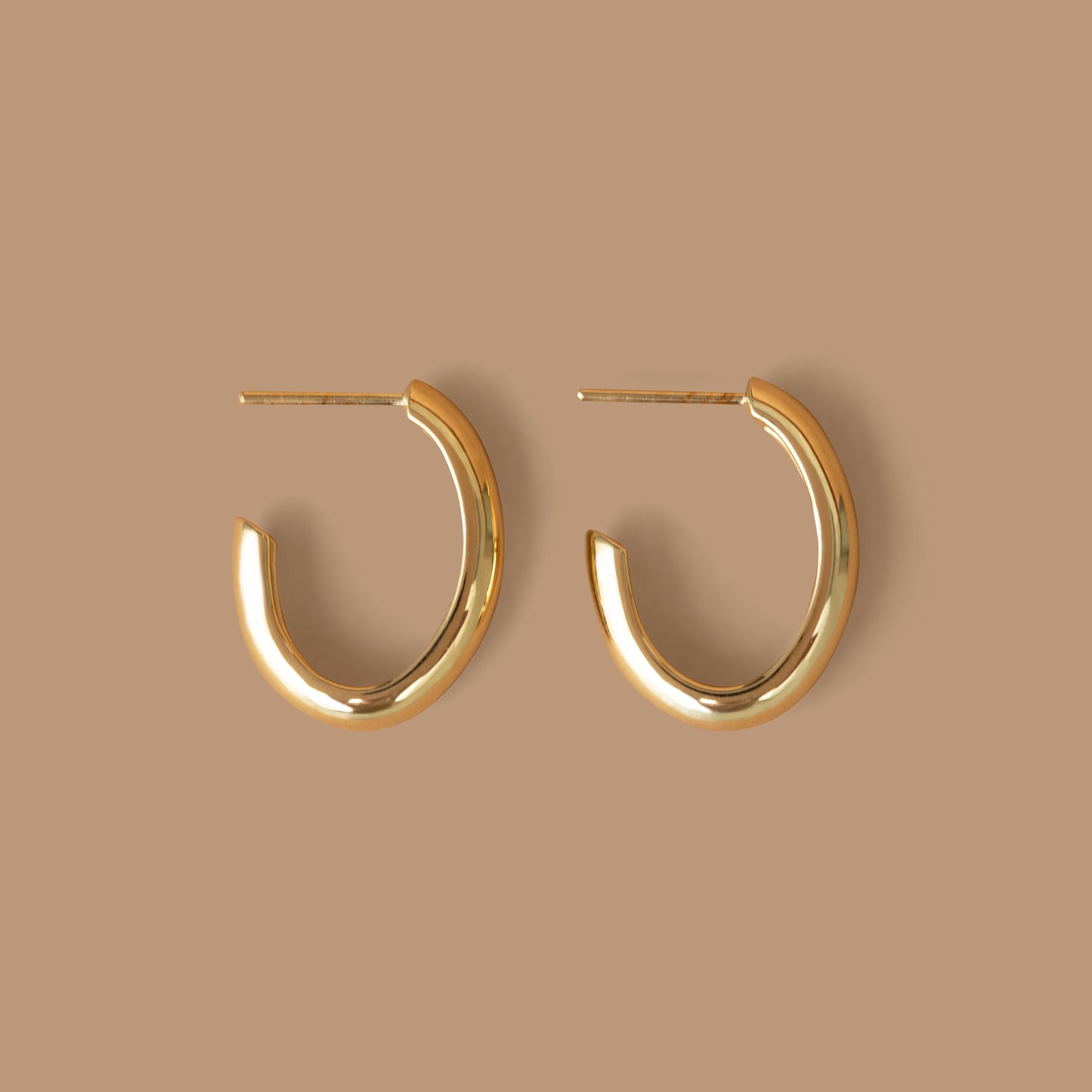 Pair of gold hoop earrings on a neutral background