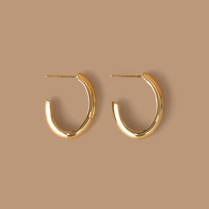 Pair of gold hoop earrings on a neutral background