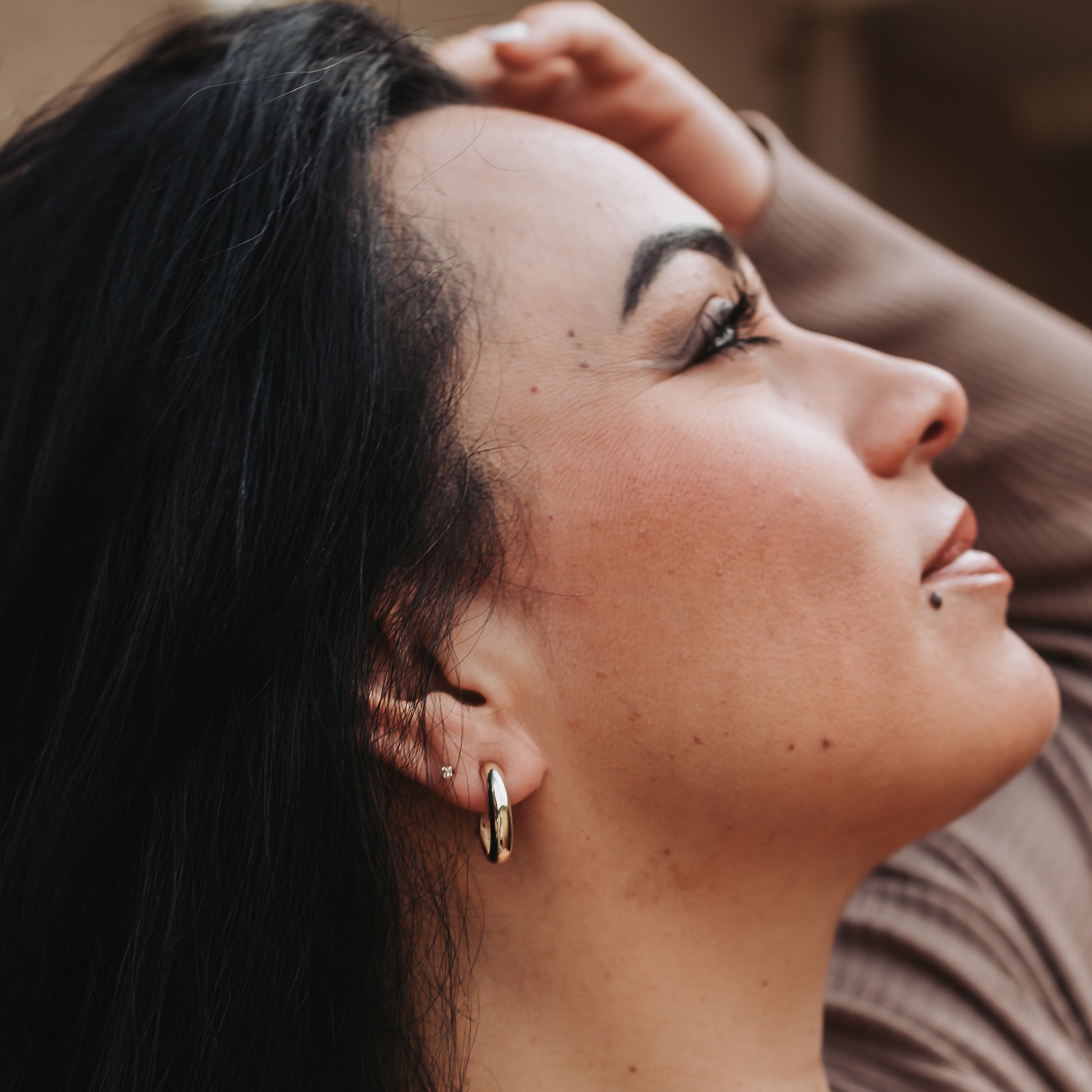 Person wearing a small silver hoop earring