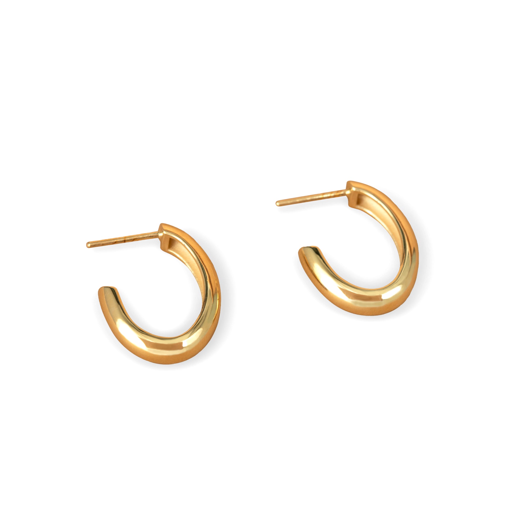 A pair of gold-colored oval hoop earrings on a white background