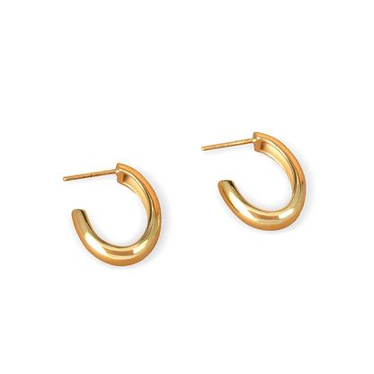 A pair of gold-colored oval hoop earrings on a white background