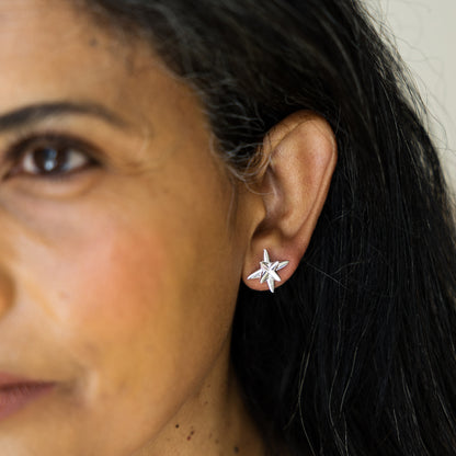 Close-up of a woman wearing silver star-shaped earrings.