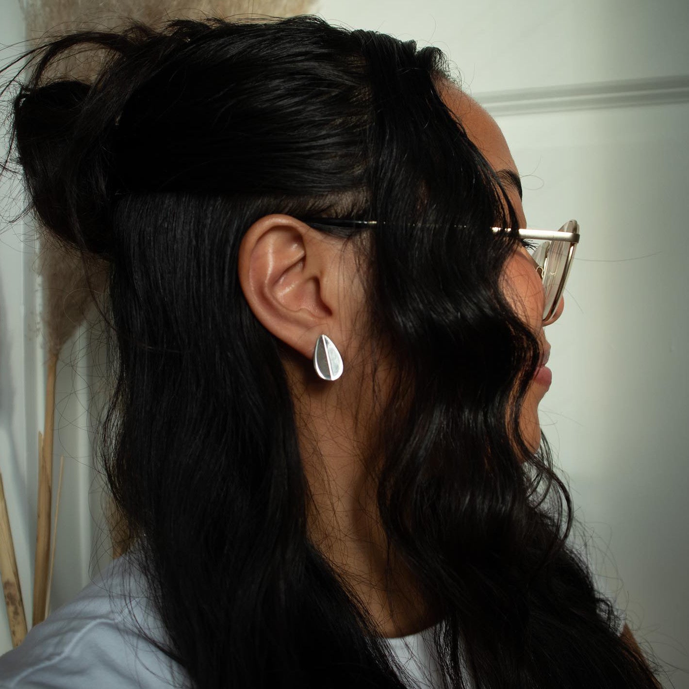 Person wearing teardrop shaped silver earrings