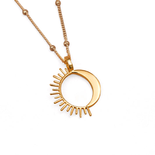 A gold-colored sun and moon necklace on a chain with 1.9mm balls, positioned against a white background.