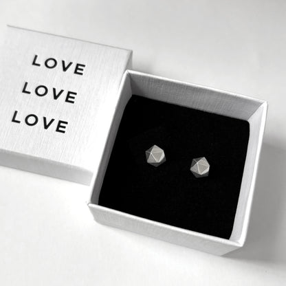 Geometric earrings in a box with 'LOVE' text on a white background