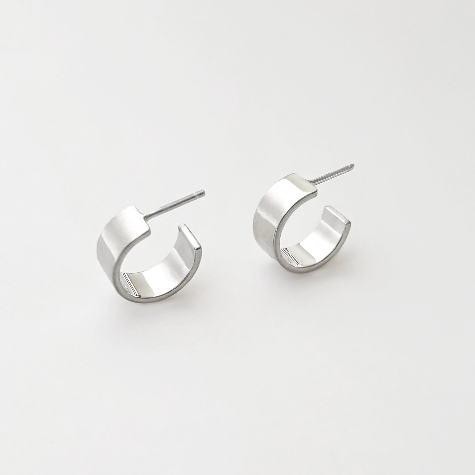 Pair of silver hoop earrings on a light gray background