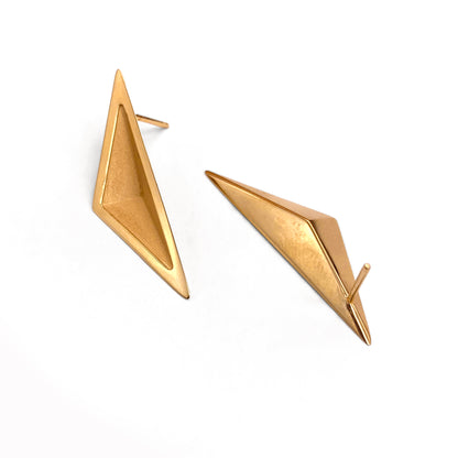 Pair of gold triangular earrings against a white background
