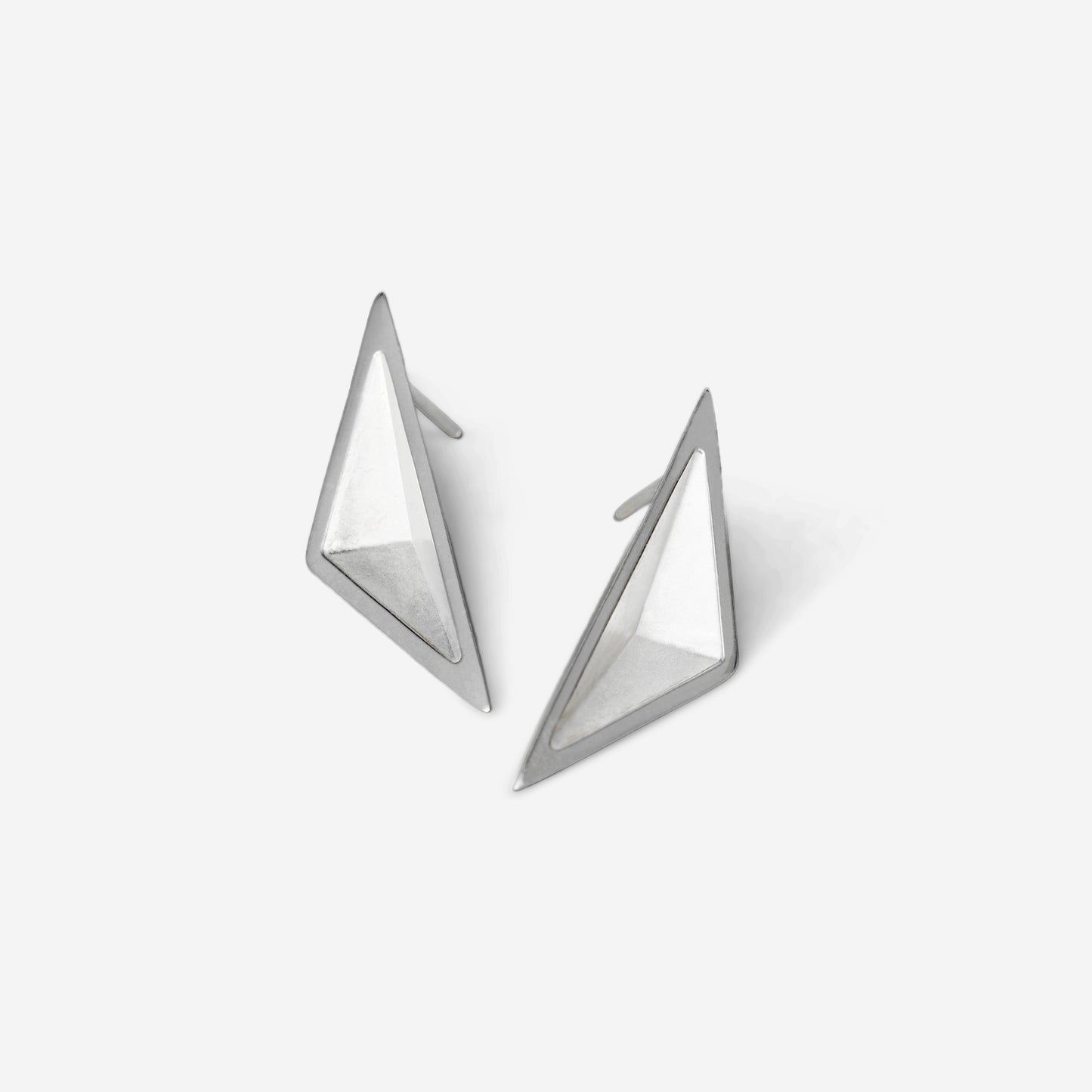 Pair of triangular geometric silver earrings against a white background