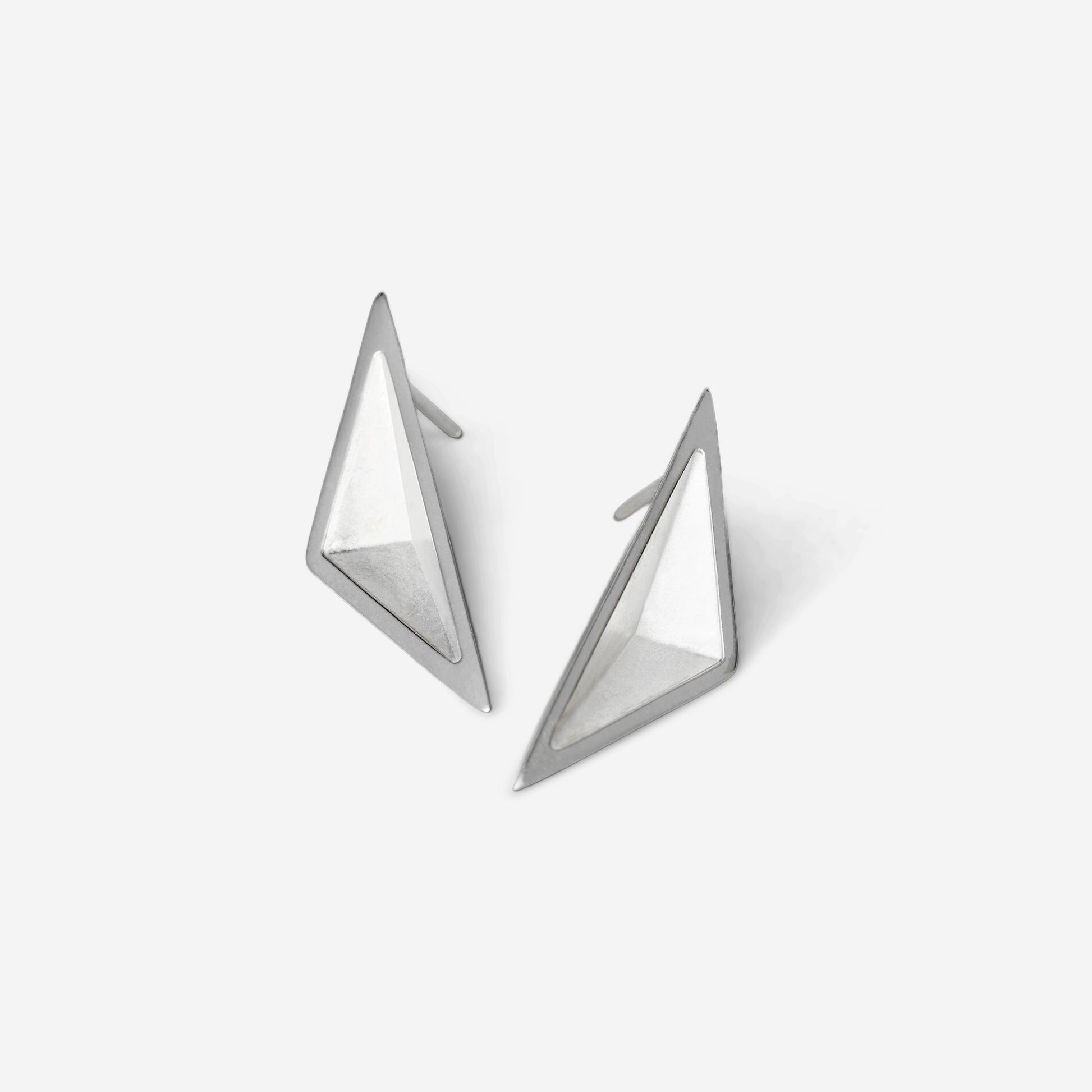 Pair of triangular geometric silver earrings against a white background