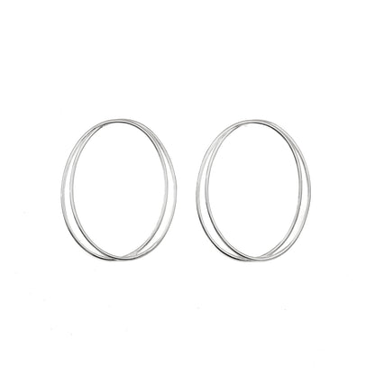 A pair of thin, oval-shaped earrings with a silver finish, displayed against a white background.
