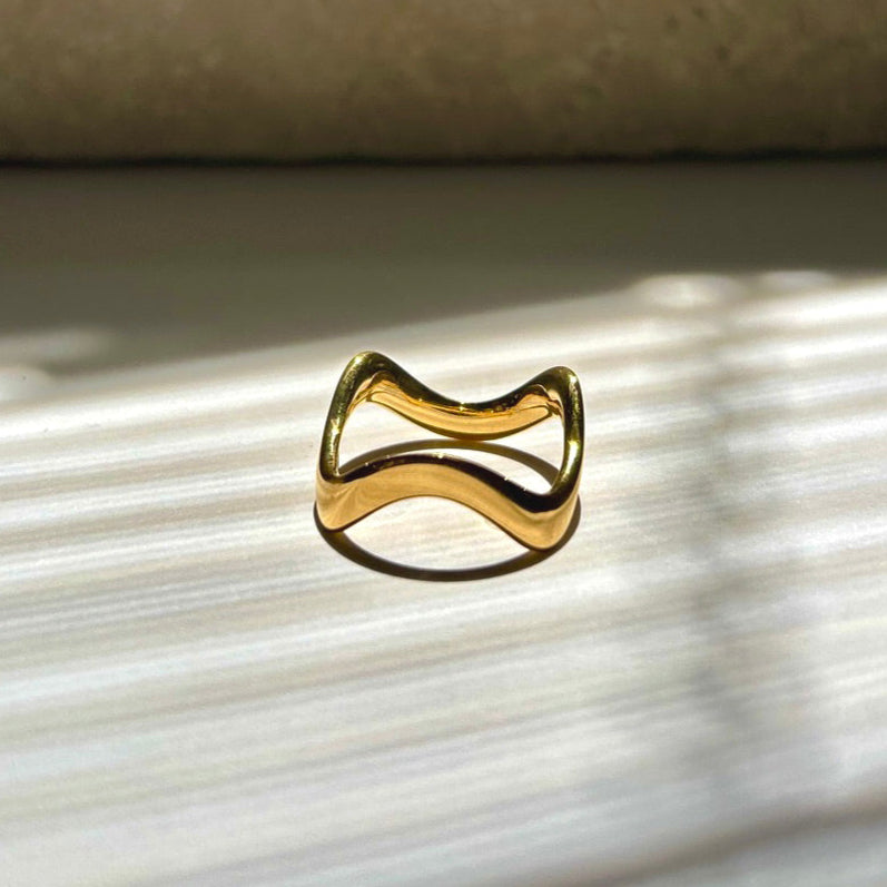 Gold ring on a textured surface with a neutral background