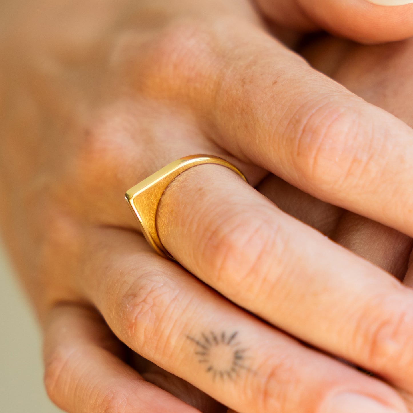 Gold ring on a finger with a blurred background