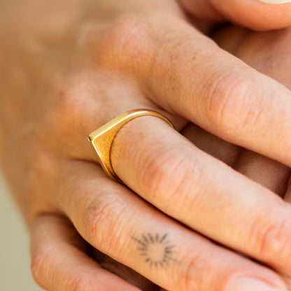 Gold ring on a finger with a blurred background