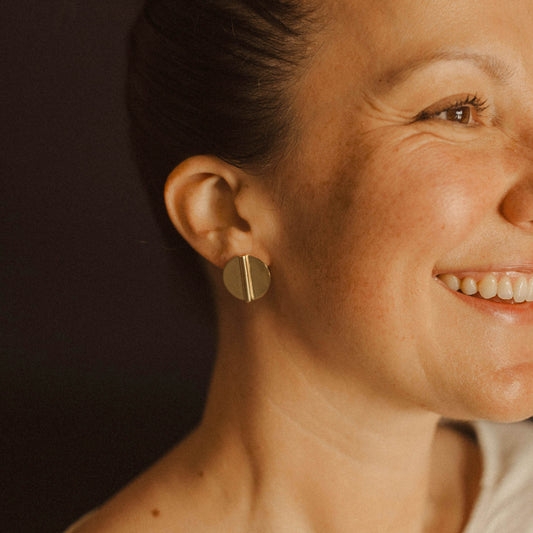 Gold Circle Coin Aegis Earring on Woman's Ear
