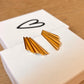 gold modern shell earrings shown laying on top of jewelry box with heart on it 