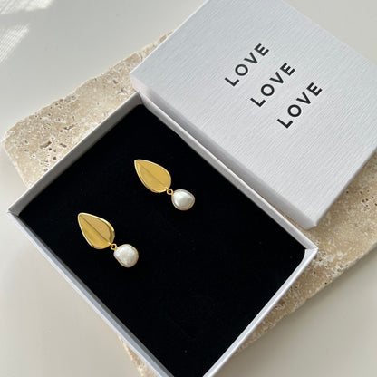 Gold and pearl earrings in a box with 'LOVE' text