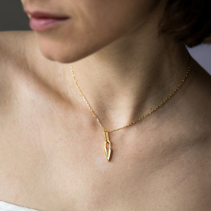 Gold necklace with a heart pendant on a person's neck