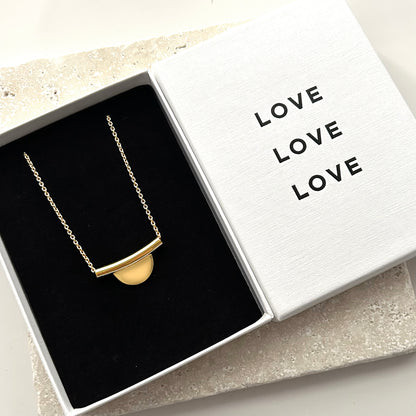 Gold necklace in a box with 'LOVE' text