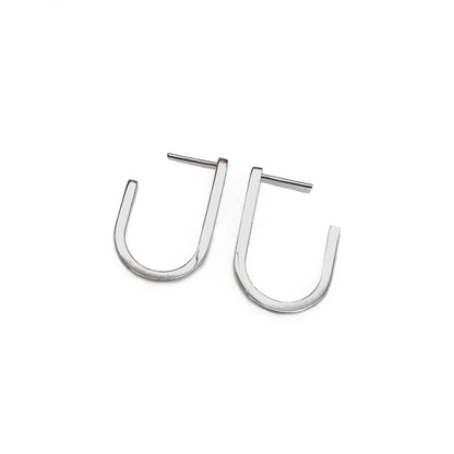 A pair of silver modern hoop earrings with a U-shape design, displayed against a white background.