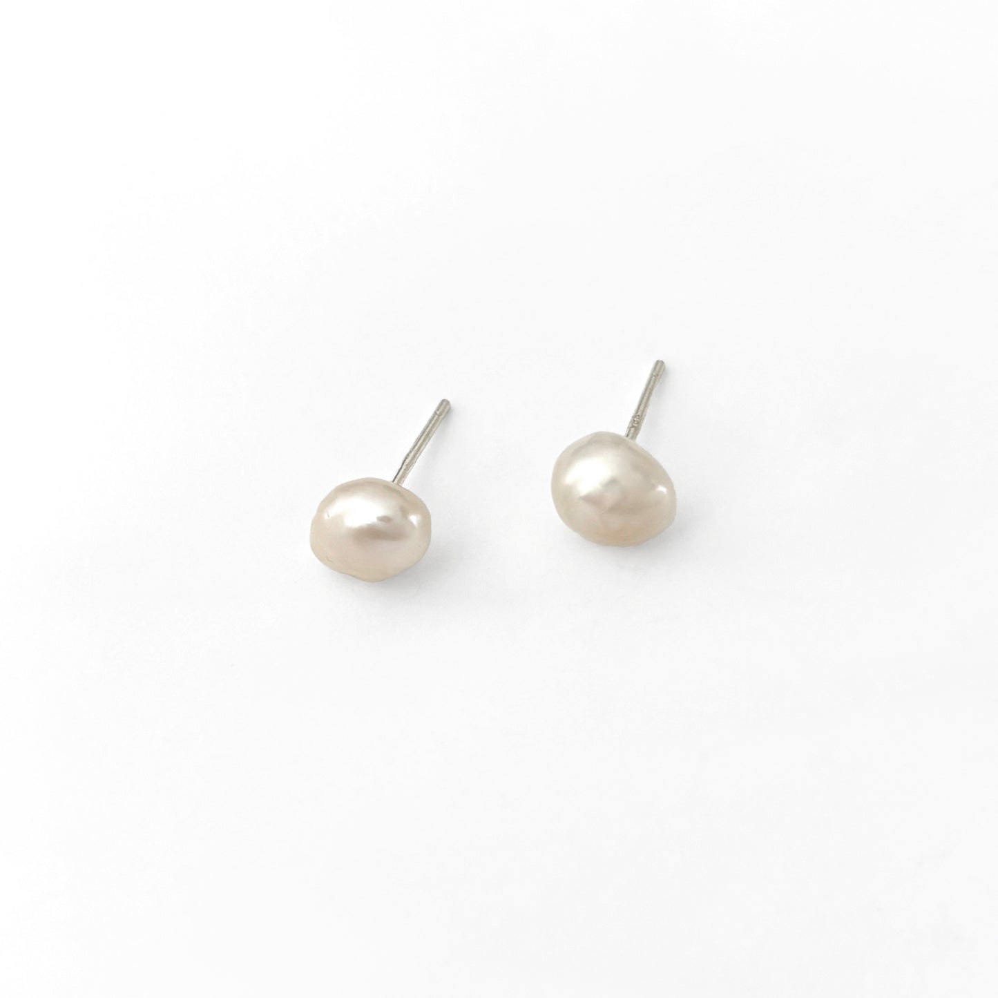 Pair of pearl stud earrings on a white background