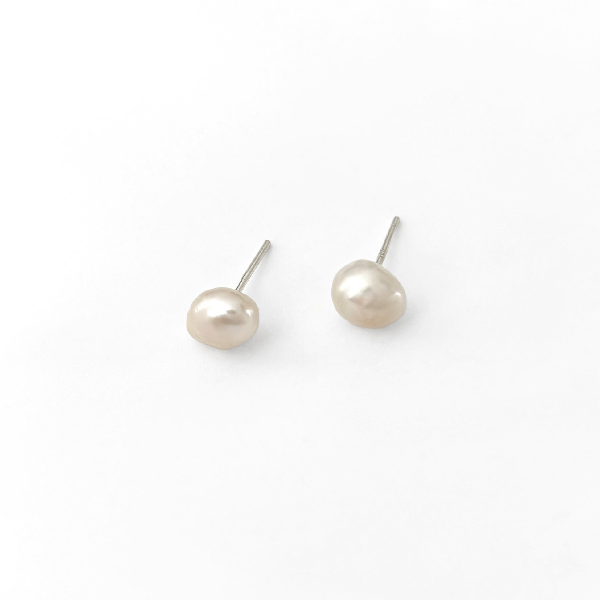 Pair of pearl stud earrings on a white background