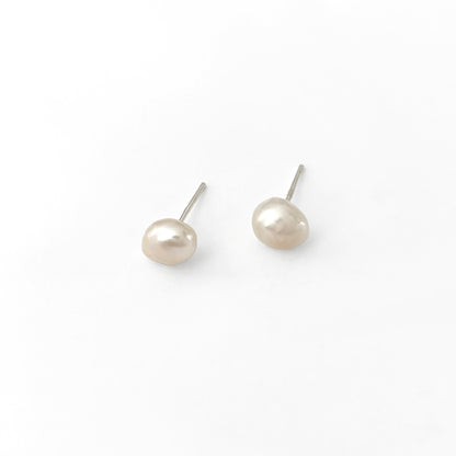 Pair of pearl stud earrings on a white background