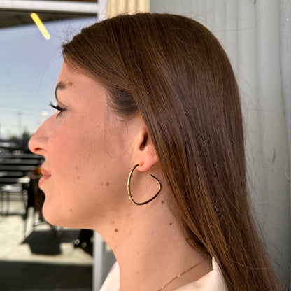 Person wearing gold hoop earrings