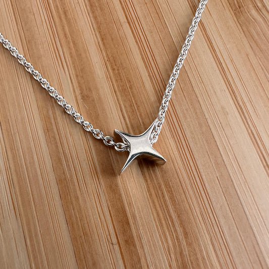 Modern Minimal Silver Star necklace jewelry shown on wood background