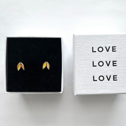 Gold leaf earrings in a black box with 'LOVE' text on a white background