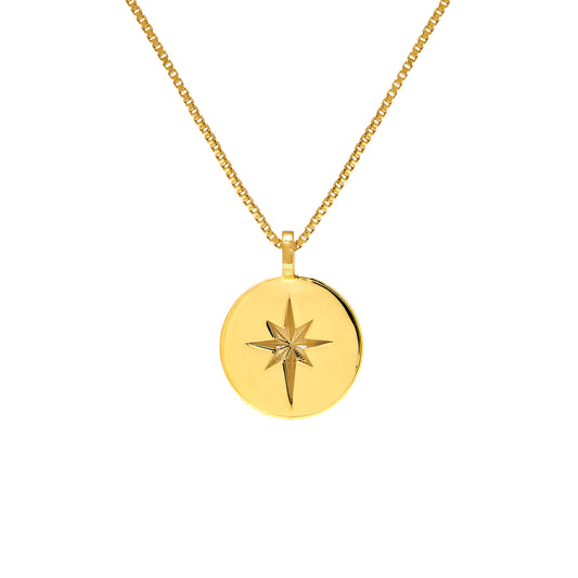 Gold necklace with a round pendant featuring a star design on a white background
