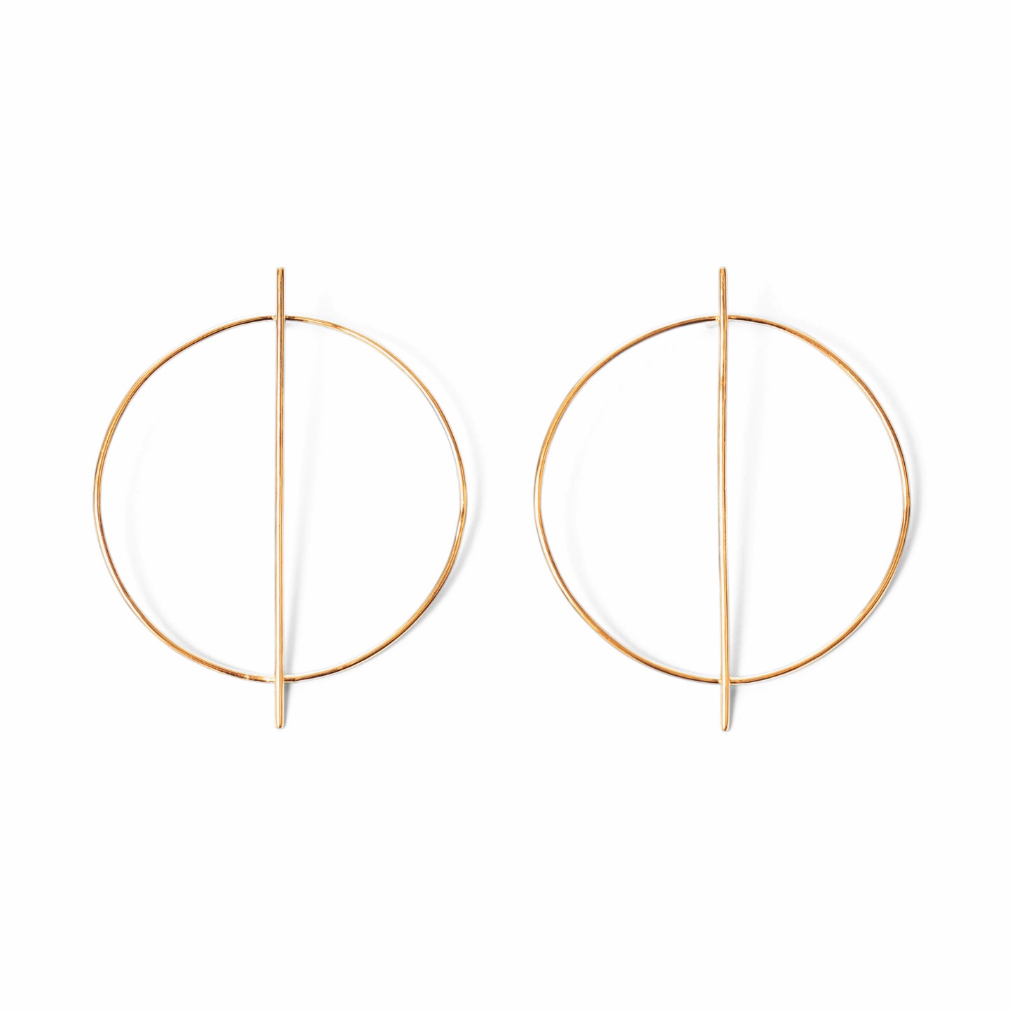 A pair of circular gold earrings with a line through them against a white background