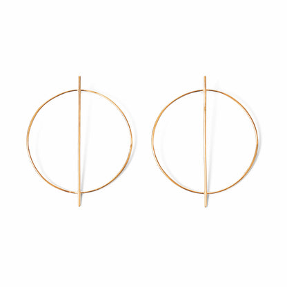 A pair of circular gold earrings with a line through them against a white background