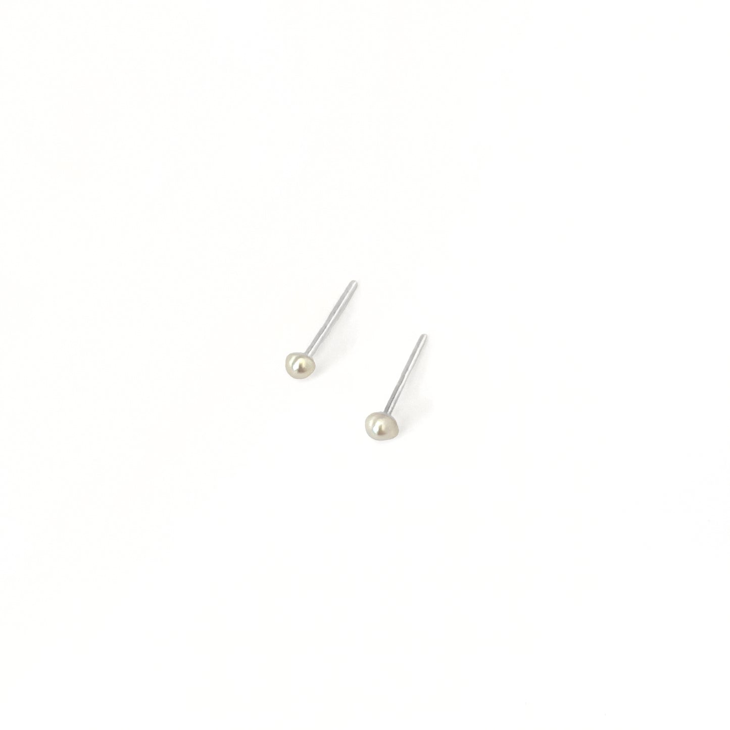 Pair of pearl stud earrings on a white background
