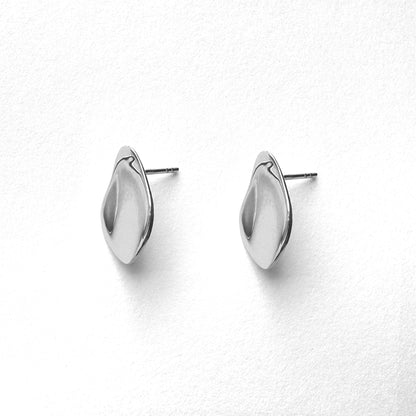 A pair of petal-shaped silver stud earrings against a white background