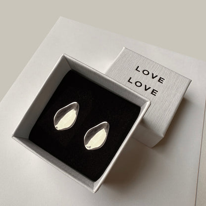 A pair of petal floral leaf earrings displayed in a box with the word 'LOVE' on it