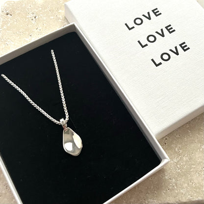 Petal-shaped pendant necklace in a box with 'LOVE' text