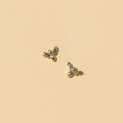 Silver Bee Earrings, shining in light on pale yellow backdrop