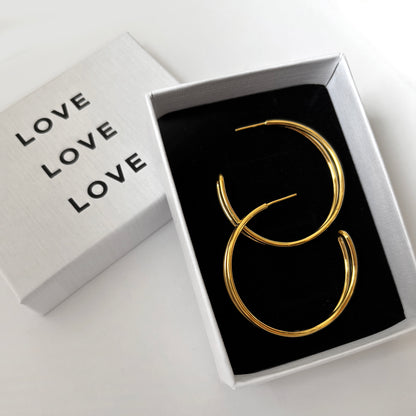 Gold earrings in a box with the word 'LOVE'.